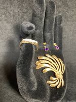 All three pieces displayed on black jewelry hand stand showing ring, earrings and brooch
