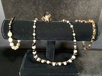 All five pieces displayed on black velvet over T-bar stand