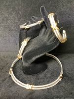 All four cable jewelry pieces displayed on black velvet stand: two bracelets, one additional bracelet, one collar necklace.