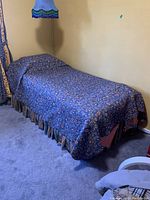 Full twin bed setup with quilt and bedskirt covering mattress and frame.