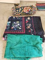 Photo showing the turquoise solid throw, navy floral reversible throw laid flat