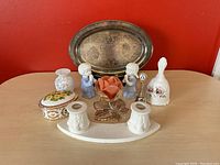 Full view of the lot on wood table against red background showing all items including the silver plated tray and various porcelain and ceramic pieces.