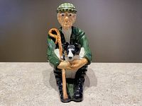 Front view of Shebeg Pottery shepherd and collie figurine showing detailed facial features and shepherd's crook.