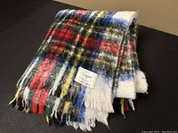 Folded view of the vintage Simpsons tartan blanket showcasing the multicolor pattern and fringed edge along with the woven brand label.