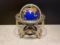 Front-facing view of globe showing lapis lazuli background and brass stand