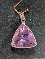 Front view of triangular amethyst pendant with 10K gold setting.