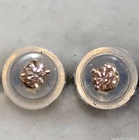 Pair of 14K gold stud earrings with lab-created diamonds in clear plastic containers.