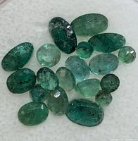Close-up of loose genuine emerald gemstones showing color, cuts, and natural inclusions