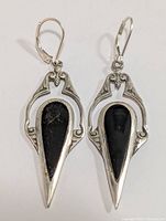 Front view of silver earring showing detailed silver framing and black onyx stone inset.