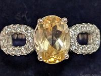 Top view showing large oval faceted citrine gemstone and CZ encrusted open geometric shapes on either side.