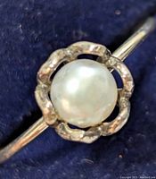 Close-up front view showing the fresh water pearl set in a floral silver bezel.