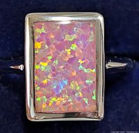 Close-up front view of silver ring with rectangular synthetic opalite stone showing colorful iridescence.