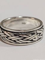 Close-up photo of the silver braided design ring showing detailing and polish on the band.