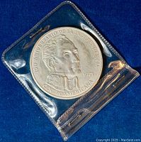 Coin obverse in plastic sleeve on blue background