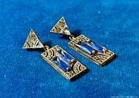 Close up of the earrings showing the marcasite detail and the rectangular blue tanzanite stones set in sterling silver with an Art Deco geometric design.