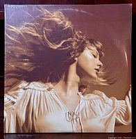 Front view of sealed Taylor Swift Fearless (Taylor's Version) vinyl album showing sepia tone image of Taylor Swift with flowing hair.