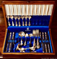 Open wooden chest showing full 40-piece set