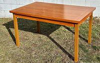 Front view of rectangular table with top closed showing tabletop condition and leg style
