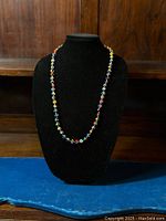 Full front view of the vintage Murano glass bead necklace displayed on a black bust form, showing the colorful bead distribution around the entire length