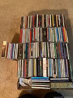 Overview photo of all CDs arranged in rows, showing spine titles and boxed sets on carpet.