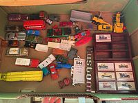 Overview of the lot showing multiple vintage diecast toy cars and the wooden display box with boxed classic model cars inside, all placed inside a cardboard box.