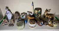 Full view of the animal and bird figurines, trinket boxes, and small decorative items arranged on a shelf.
