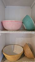 Pair of Green's mixing bowls, one pink and one teal, showing textured exterior and white interior