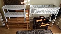 Photo showing white wicker plant stand with basket alongside plastic and wooden shoe racks and wooden magazine holder arranged on floor.