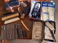 Grouped display of grooming items including brushes, clippers in box, nail tools, and make-up neck mirror.