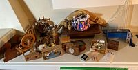 Overview of lot showing wooden boomerangs, miniature spinning wheel, wood animal toys, wooden thermometer, keepsake boxes, nautical trinkets, and model ship.