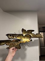 Brutalist brass and copper sculpture held up showing its shape and metal wire details