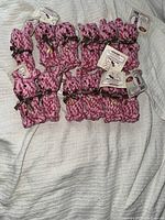 Twelve pink rope bunny chew toys arranged on a white textured surface, showing the entire lot.