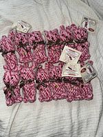 Set of 12 pink rope bunny dog toys arranged together on a light colored fabric surface.