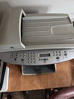 Top view of the HP LaserJet 3055 printer showing the control panel with buttons for fax, copy, scan, numerical keypad, and LCD display along with the top scan bed.