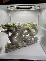 Front view of hand carved jade dragon showing head and body detail