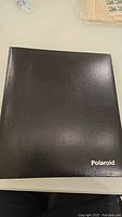 Photo of a black Polaroid binder showing exterior cover