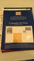 Page titled 'Canada At War World War I & II,' featuring a commemorative stamp, first day cover with a postmark dated 1939, and 24k gold leaf decoration.