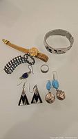 Photo of all items in lot including earrings, rings, bracelets, and watch bracelets.