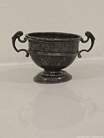 Mini silver trophy cup with handles, tarnished silver surface