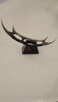 Klingon Bat'leth letter opener displayed on stand showing weapon shape and display piece.