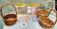 Photo showing three vintage woven baskets and five packages of Easter-themed stickers arranged on a light green surface.