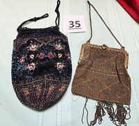 Pair of beaded purses on light green fabric: Victorian cinch sack bag with rose beadwork on left, 1920s golden-brown metallic beaded purse with beaded fringe on right