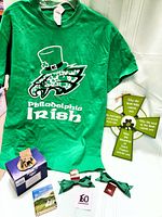Full view of green Philadelphia Irish T-shirt with Eagles logo, wooden Celtic cross, cottage sculpture box, mini book, and green bows.