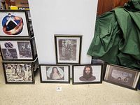 Seven framed Tolkien-themed images arranged on the floor. Includes character portraits and group scenes.