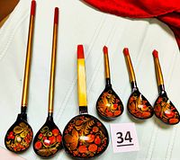 Overall view of all 6 items laid out on white fabric surface showing their sizes and painted decorations