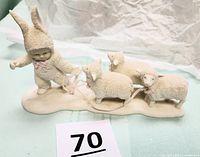 Front view of Dept. 56 Snowbabies figurine showing child in bunny suit leading 3 sheep on base with missing shepherd staff.