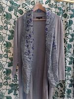 Front view of the grey Banana Republic duster cardigan with floral silk scarf draped over it on a hanger