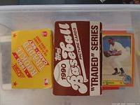 Boxes of 1990 Score Rookie and Traded baseball cards and 1990 Topps Baseball "Traded" Series cards in a bin.