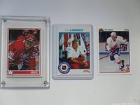 Front side of three hockey cards including two in plastic holders, featuring Eric Lindros in red OHL uniform and white hockey jersey.