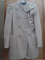 Full view of the off-white wool-cashmere blend FCUK coat showing double-breasted button front, ruffle detail on right side, and long sleeves with buttoned cuffs.